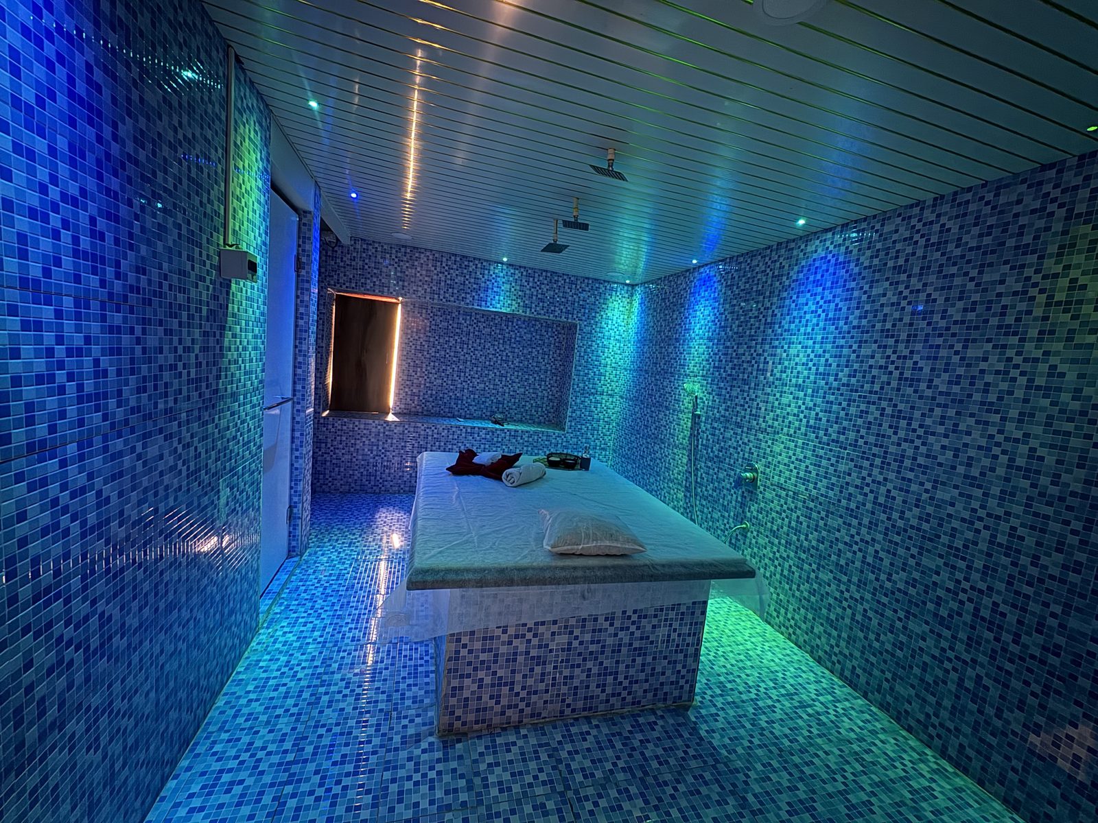 Hammam room with mosaic tiles and a treatment table